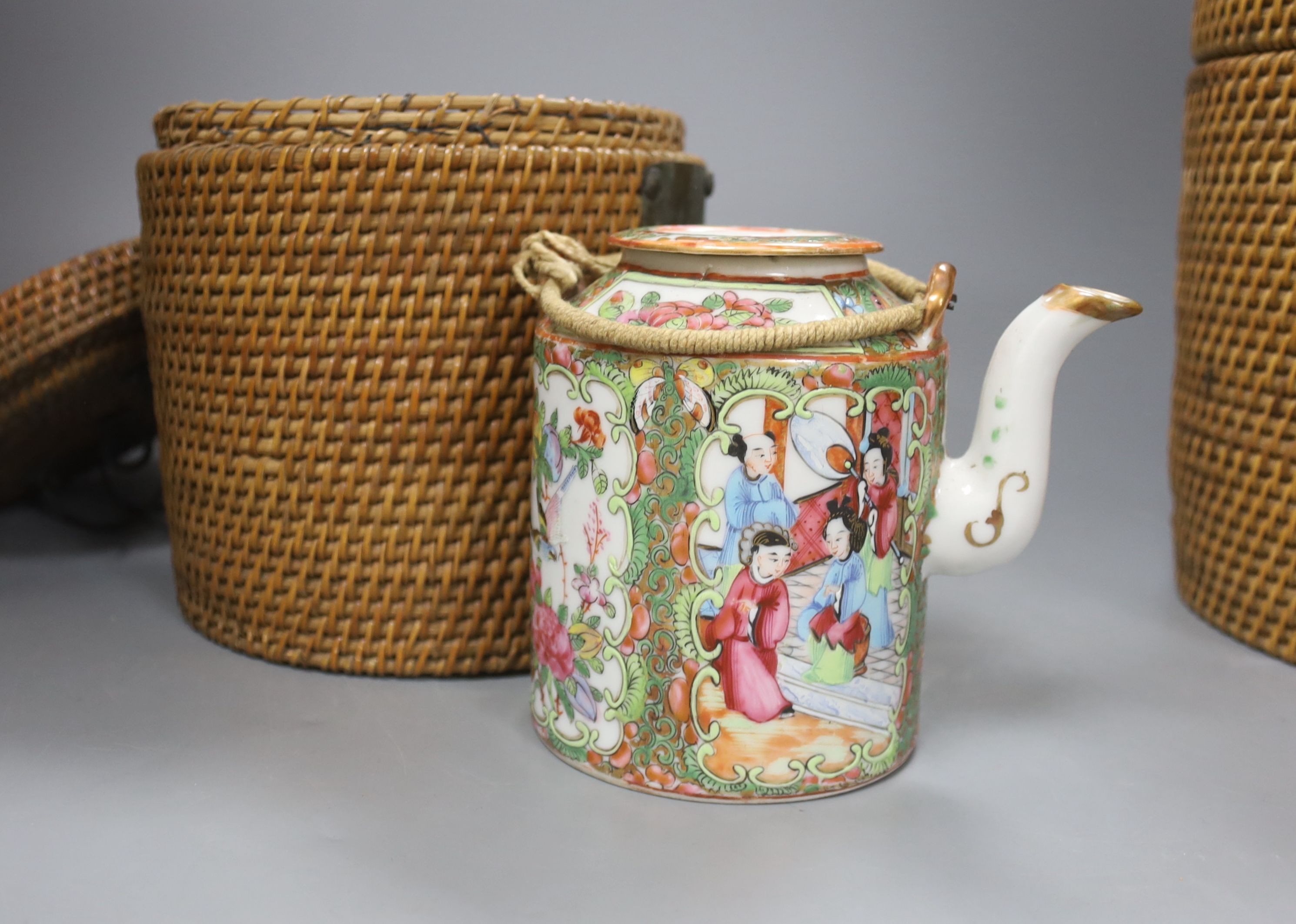 Three late 19th/early 20th century Chinese famille teapots, two in baskets and a similar dish, dish 29.5 cms diameter.